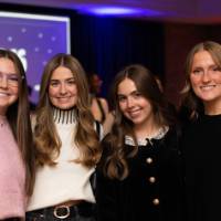Four grads smile a Toast